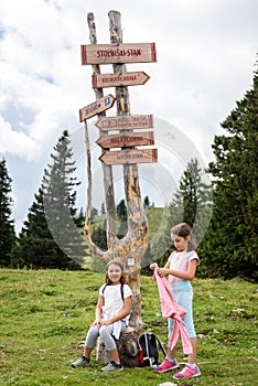 Children in frontÂ Wooden Signpost on Velika Planina in Slovenia